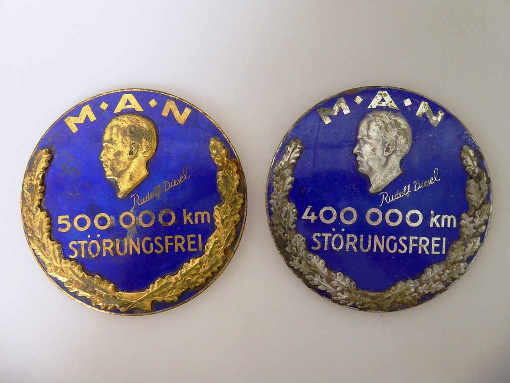 2 Plaketten MAN - Metall emailliert, mit Bildnis von Rudolf Diesel, 400.000 KM u. 500.000 KM "