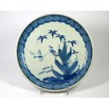 A Japanese Arita porcelain dish, painted in underglaze blue with a flowering plant