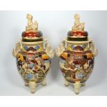 A pair of Japanese Satsuma vases with covers, painted with warriors and nobles