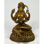 A Tibetan bronze Buddhistic figure of a four armed lady seated on a separate base