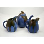 A three piece blue tea set with runny brown glaze