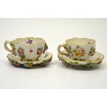 A pair of Meissen floral encrusted cups and saucers,