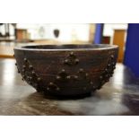 A wooden bowl with a decoration made of farthings