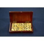 A boxed miniature domino set in bone and ivory