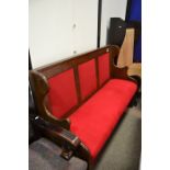 A three seater settle in red upholstery