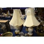 A pair of lamp stands with cream shades