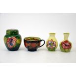 A group of four Moorcroft pieces including a clematis vase, a hibiscus ginger jar, a hibiscus