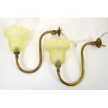 A pair of Arts and Crafts brass wall lights with frosted glass shades