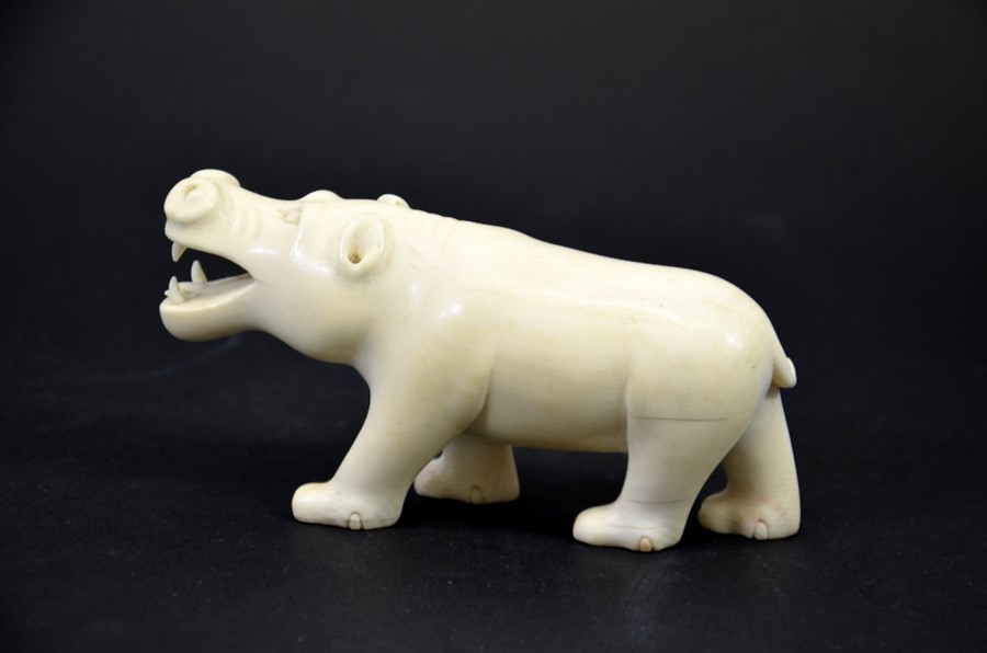 λ A 19th century African carved ivory figure of a hippo