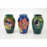 A group of three Moorcroft vases, including Clematis, Hibiscus and Anemone