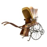 A Victorian wooden pram with brown leather studded hood and interior