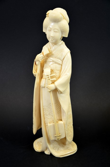 λ A 19th century Japanese carved ivory okimono of a Geisha, Meiji,