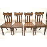 A set of four William IV Gothic Revival oak hall chairs