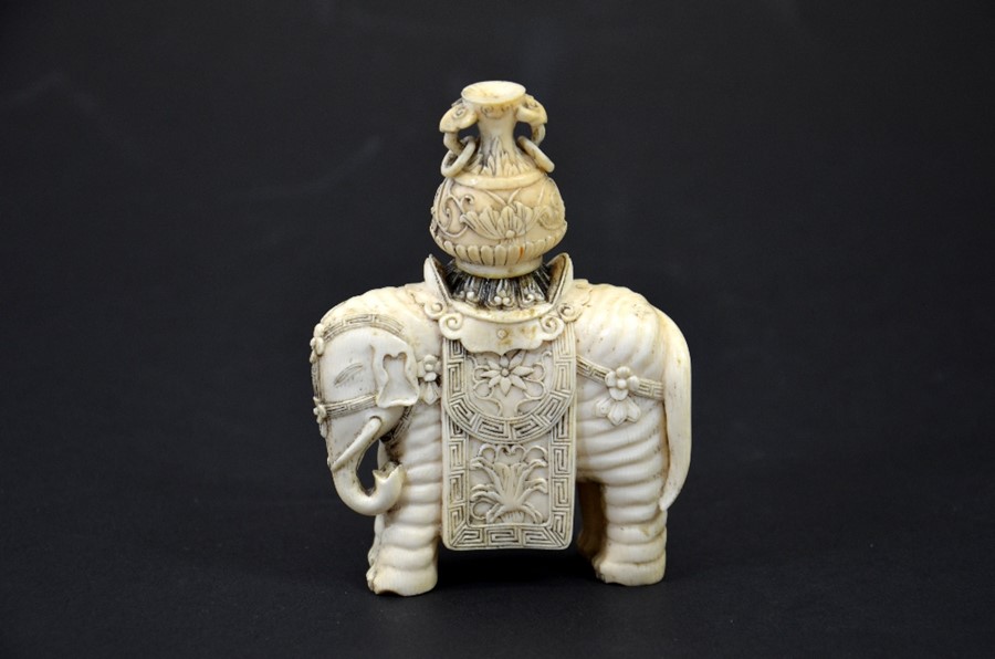 λ A 19th century Chinese carved ivory figure of an elephant with vase on its back