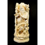 λ A 19th century Indian carved ivory figure of a deity playing the pipe
