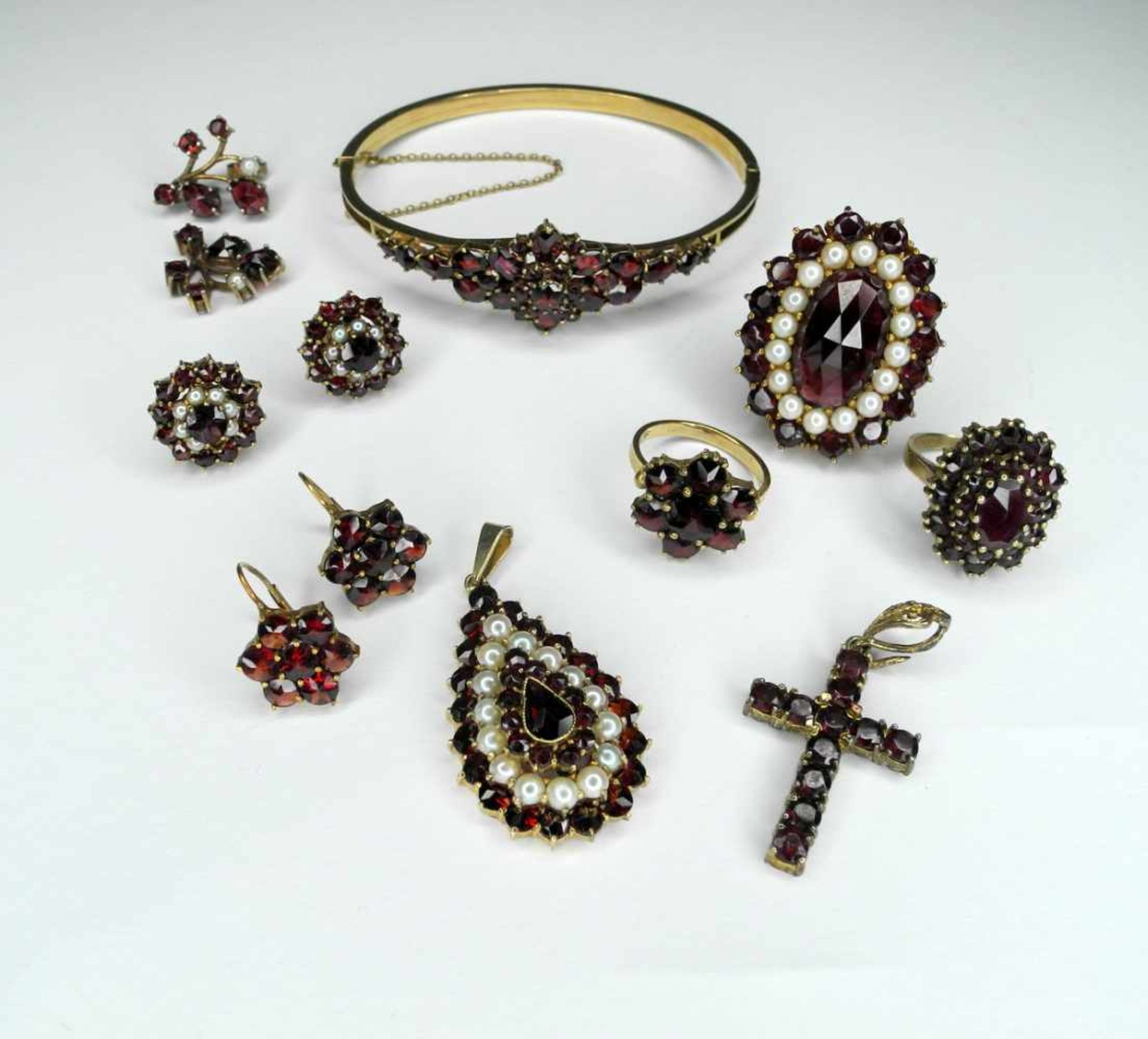 12-teiliges Set mit Böhmischen GranatenBestehend aus Ringen, Armreif, Ohrsteckern und Anhängern.