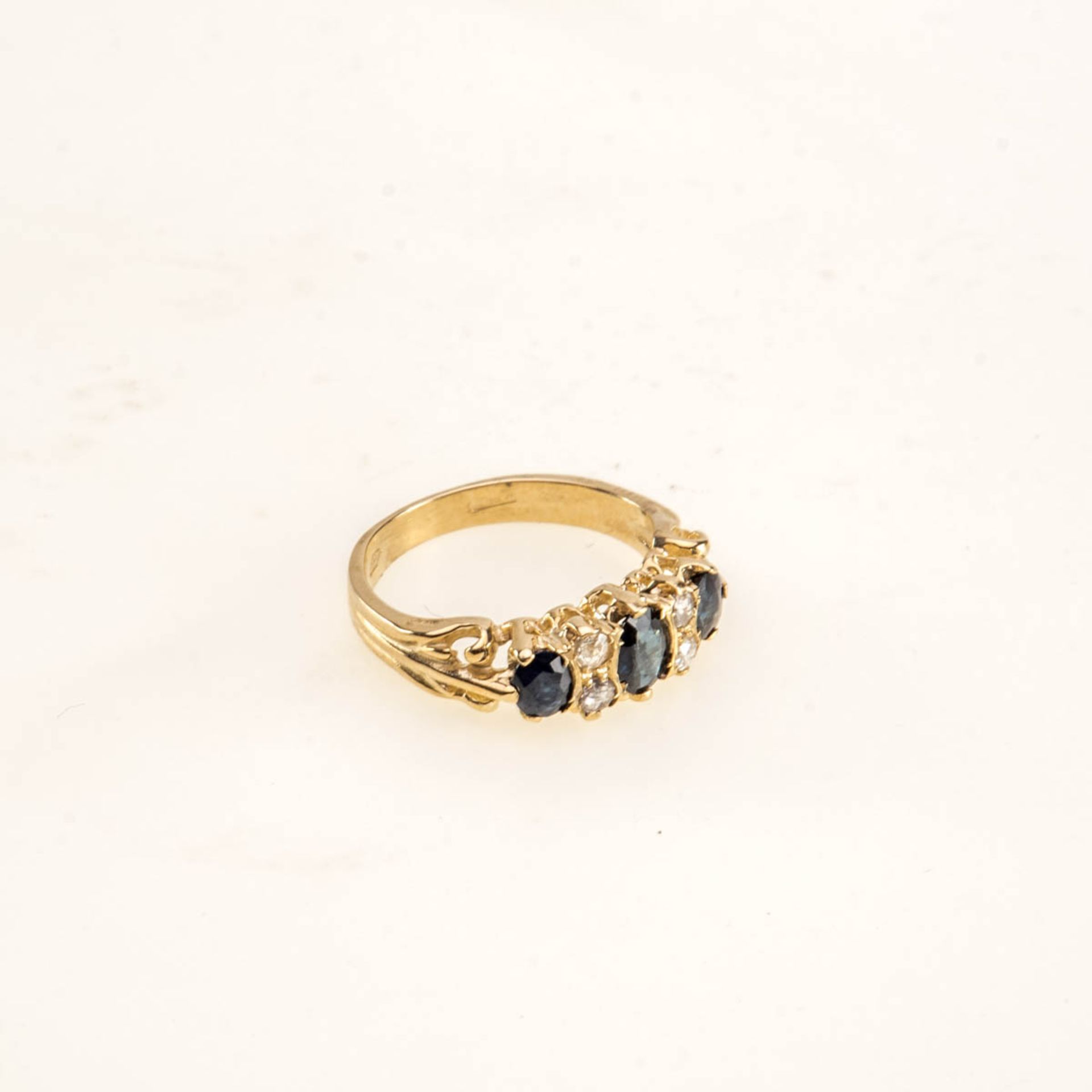 Saphir-Diamant-Ring 375er Gelbgold. Schmale Ringschiene, Schulter sich gabelnd. Ringkopf mit drei