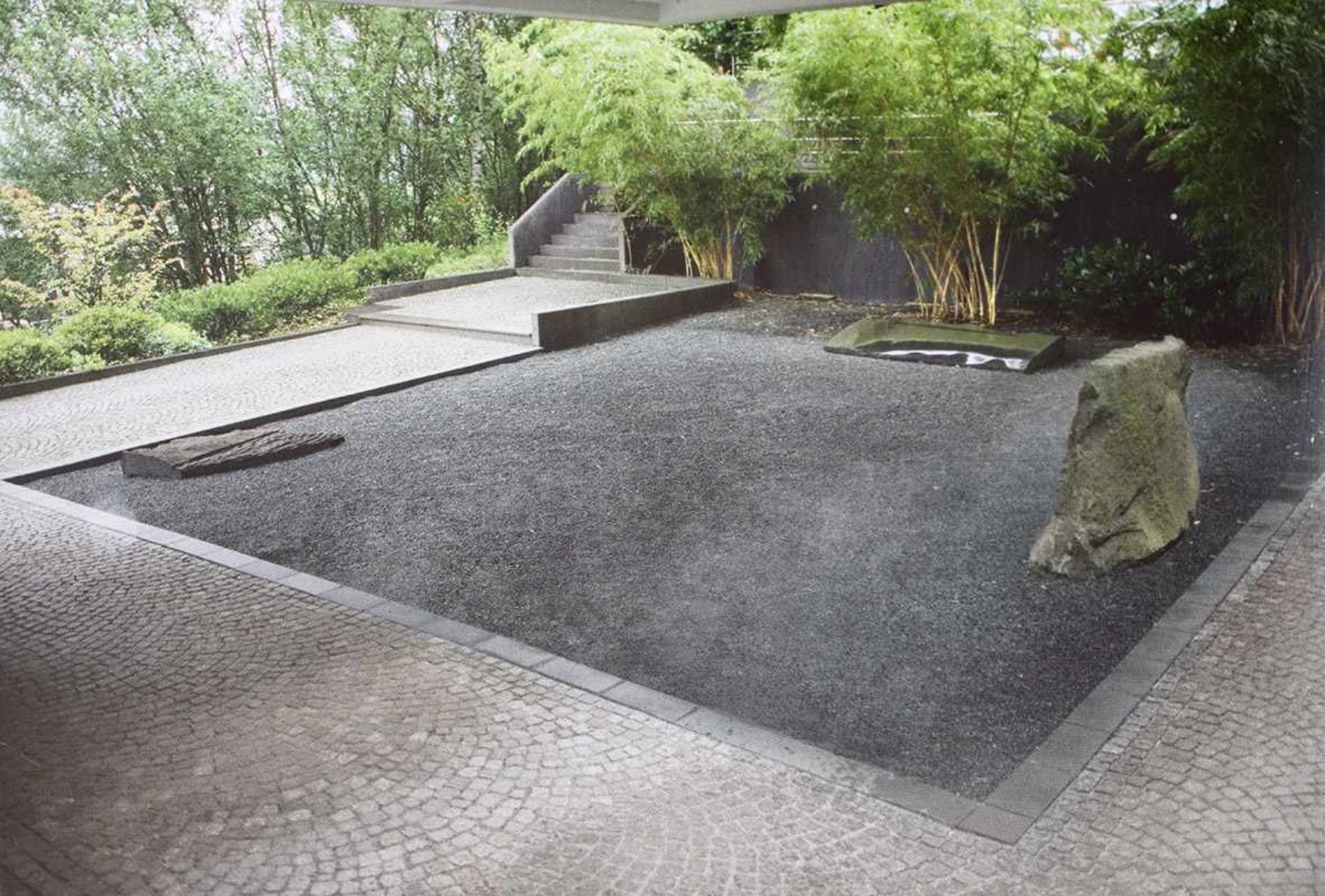 Japanischer GartenHeinz Mack* (*1931)1998Karree aus Basalt-Split mit drei skulpturalen Steinen.