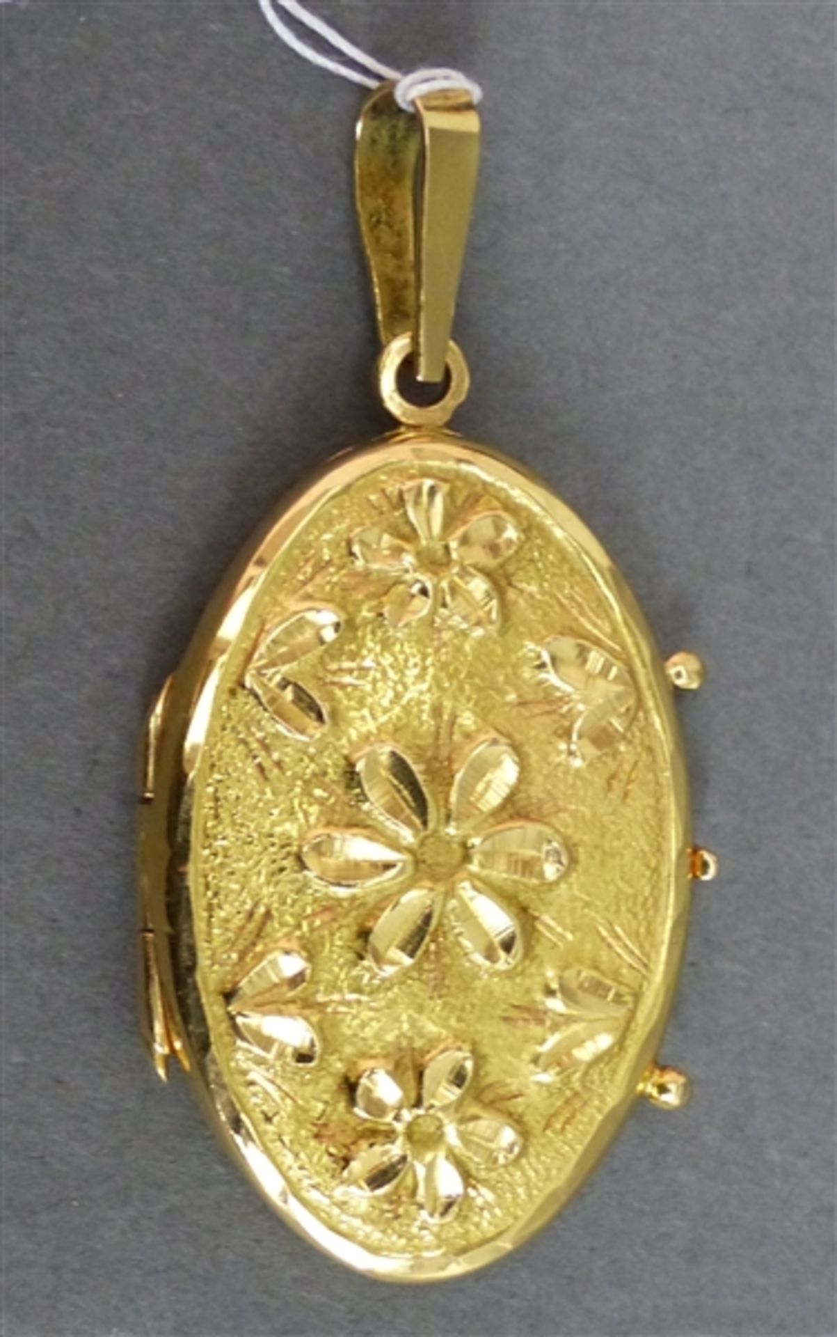 Medaillon 18 kt. Gelbgold, Reliefarbeit, Vorderseite mit Blumen, oval, klappbar, ca. 9 g schwer, h