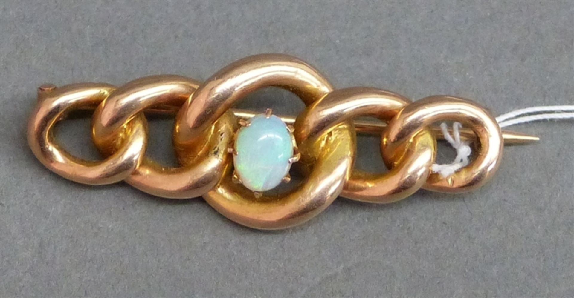 Brosche, um 1900 14 kt. Rotgold, 1 ovaler Opal, Gliederform, ca. 4,5 g schwer, b 4 cm,