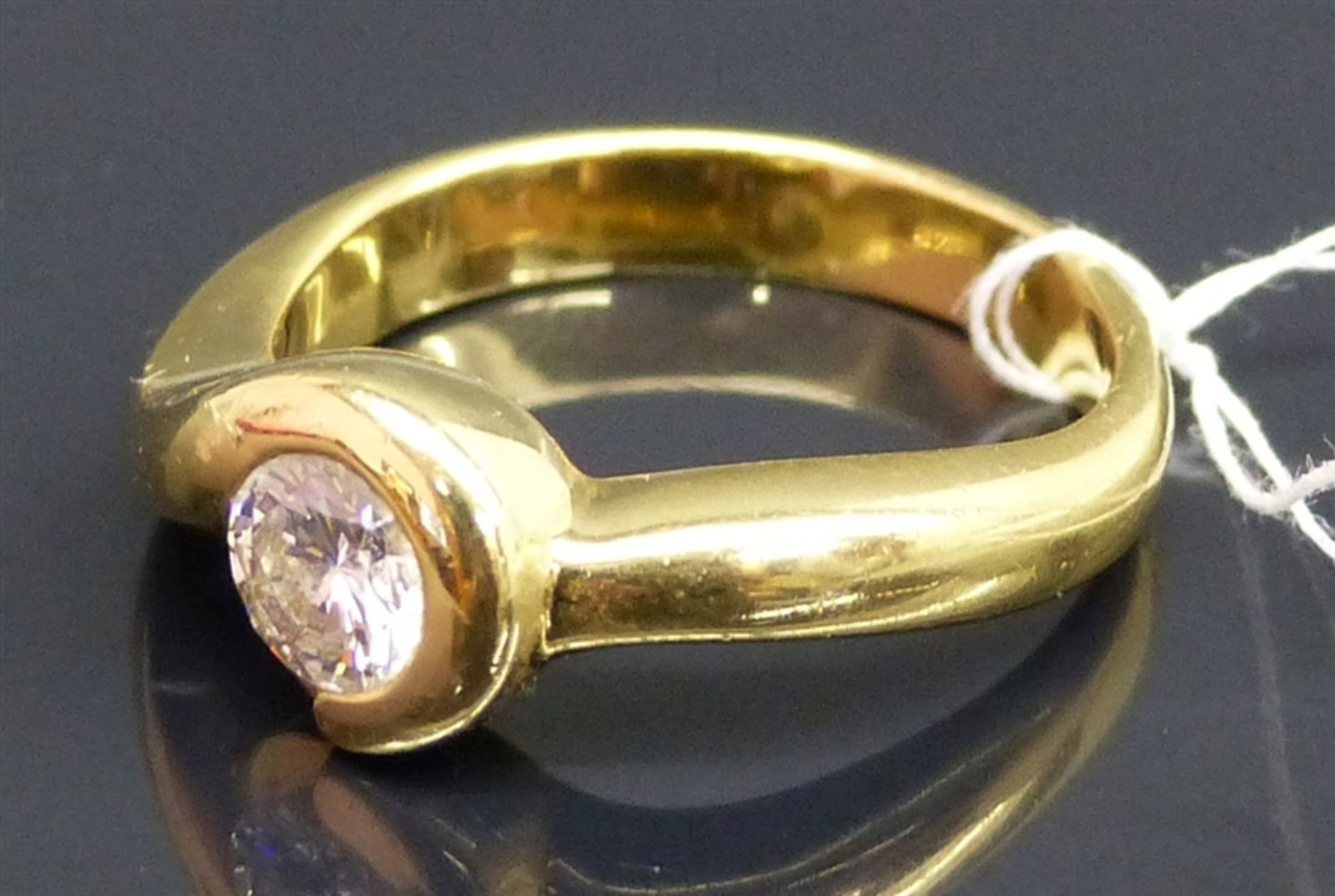 Solitärring 18 kt. Gelbgold, 1 Brillant 0,66 ct., wesselton, si, moderne Fassung, mit