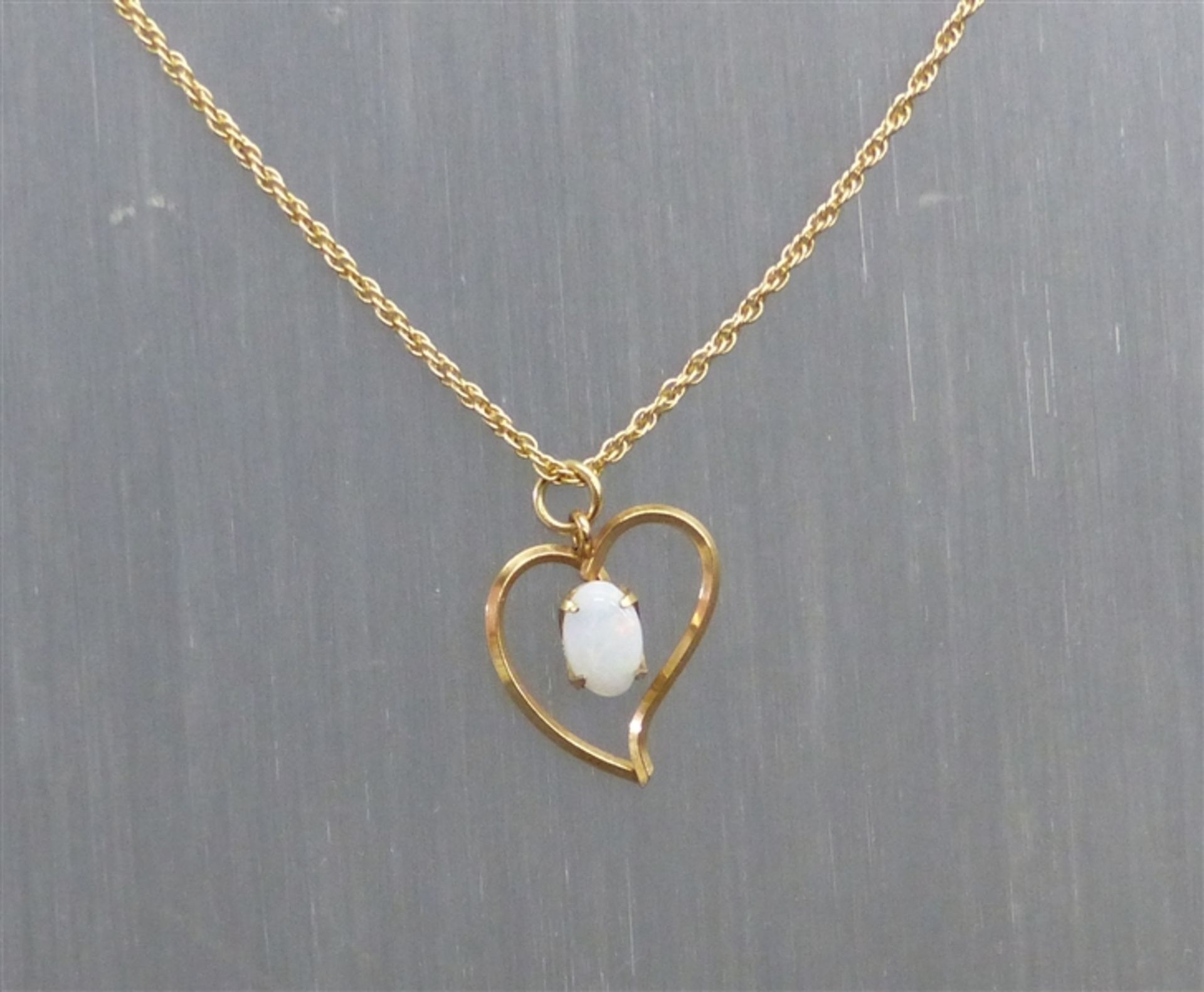 Herzanhänger 14 kt. Gelbgold, 1 ovaler Opal, durchbrochen gearbeitet, an 14 kt. Kordelkette, l 45