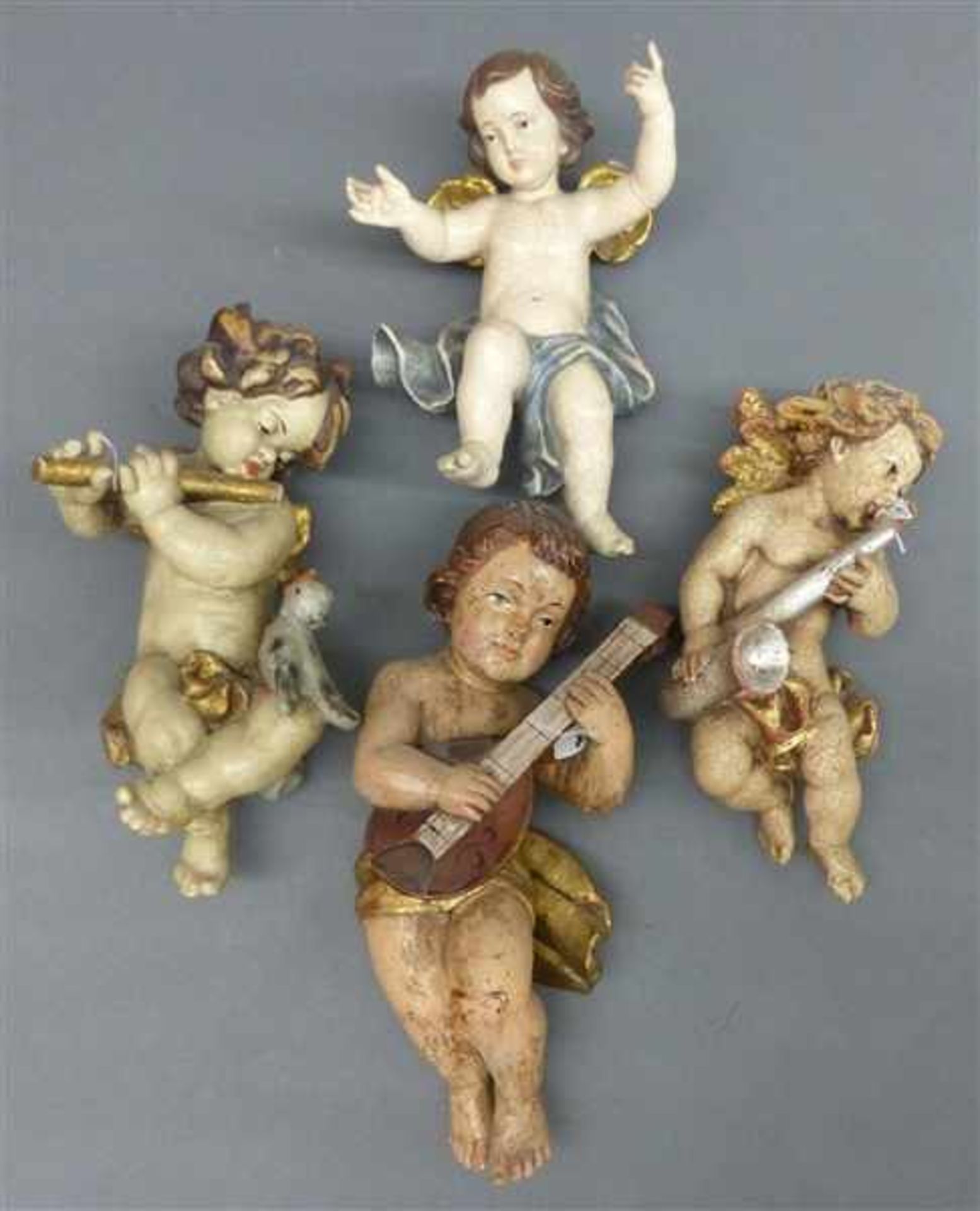 KonvolutHolzskulpturen, vier Puttidarstellungen, teilweise musizierend, Grödnertal, 20. Jh.,
