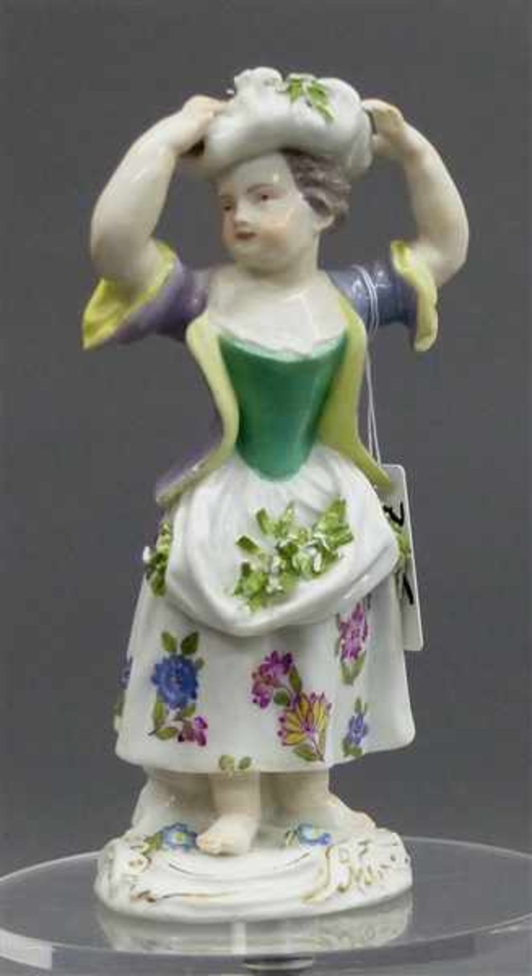 Porzellanskulpturjunges Mädchen mit Blüten im Kopftuch, sowie in der Schürze, bunt bemalt, bestoßen,