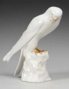 Falke Weiß, glasiert. Auf Felssockel stehende Darstellung eines Falken. Goldstaffage.