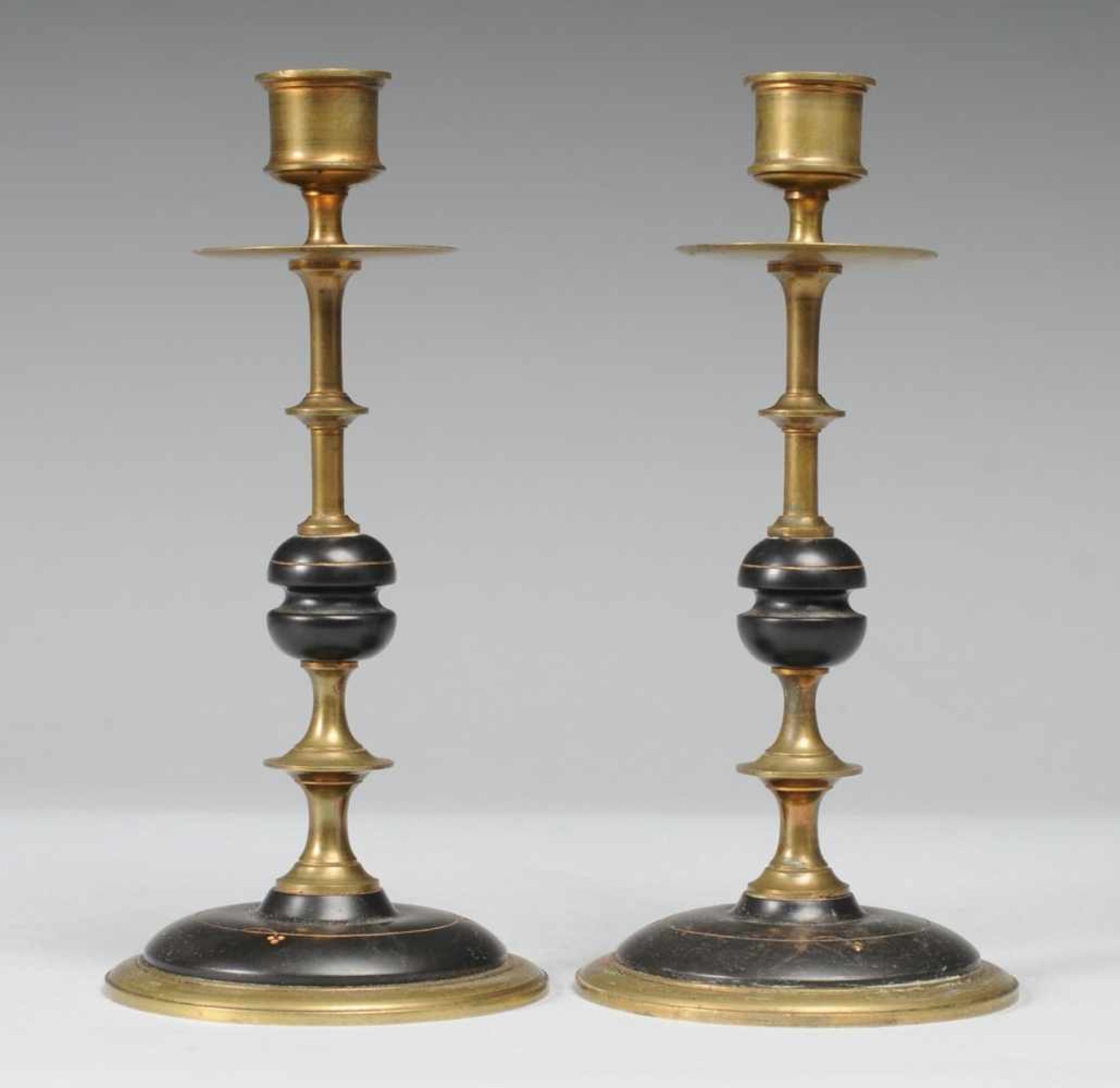 Paar Tischleuchter Messing u. schwarzer Stein (?), part. vergoldet. Über rundem ansteigendem Fuß