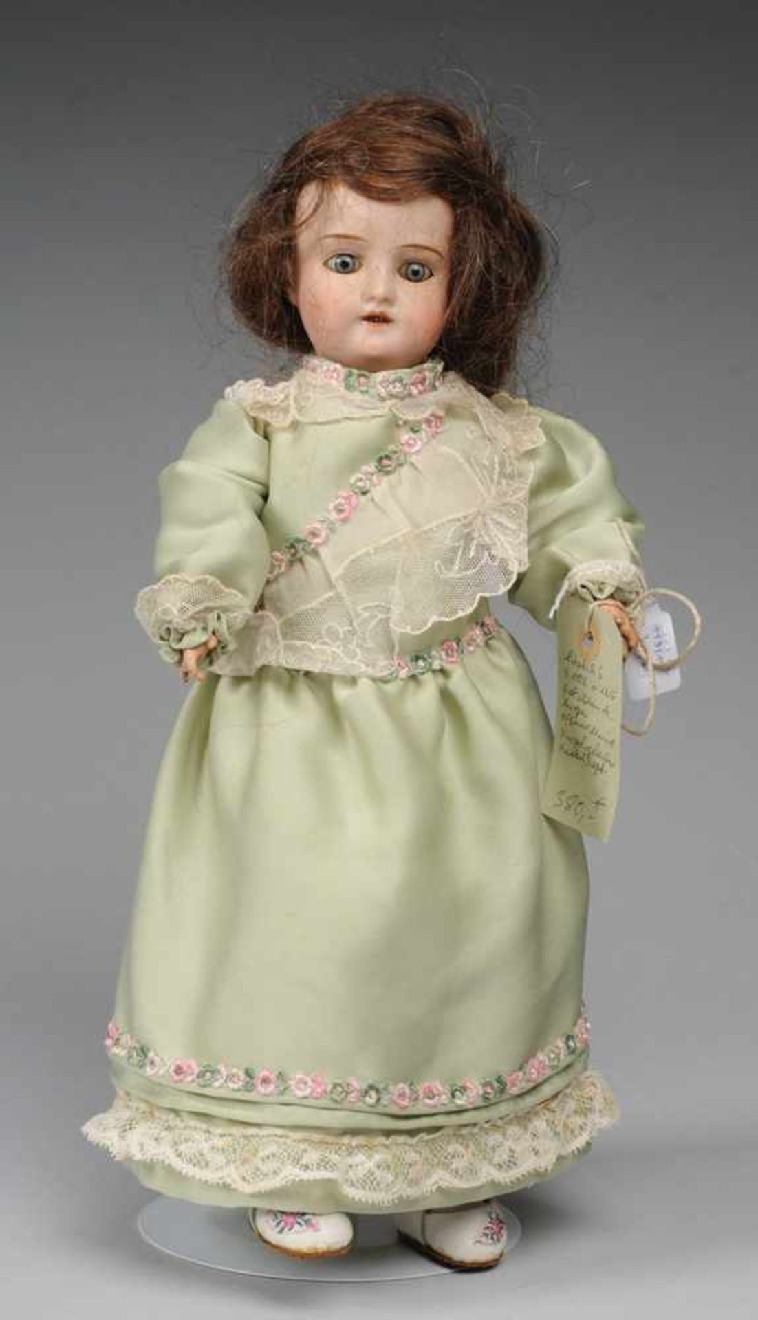 Puppenmädchen Modell 1909. Kurbelkopf aus Biskuitporzellan mit aufgeklebter Perücke, gemalten Brauen
