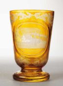 Andenkenbecher "Wiesbaden" Farbloses Glas, gelb gebeizt. Formgeblasen. Konischer Korpus auf massivem