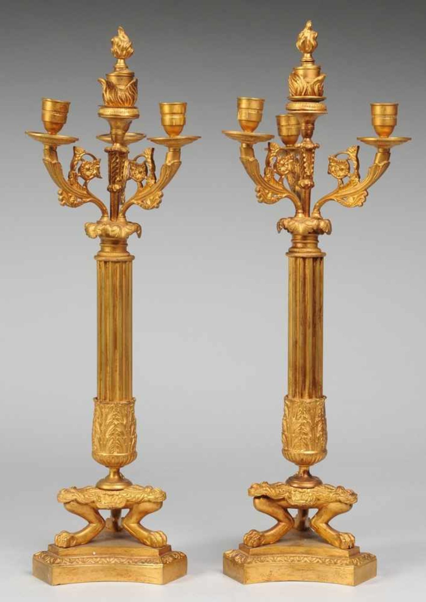 Paar Empire-Kandelaber 3-flg. Bronze, vergoldet. Auf konkav geschweifter Plinthe von 3 Löwenbeinen