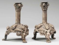 Paar Tischleuchter Messingguss, wohl versilbert. Auf 3 Tatzenfüßen in romanischer Manier