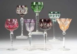 Sieben RömerFarbloses Kristallglas, part. rot, grün, violett u. orangefarben überfangen. Scheibenfuß