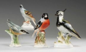 Vier Vogel-PorzellanfigurenWeiß, glasiert. Versch. Modelle, u.a. Kiebitz u. Kleiber. Polychrome