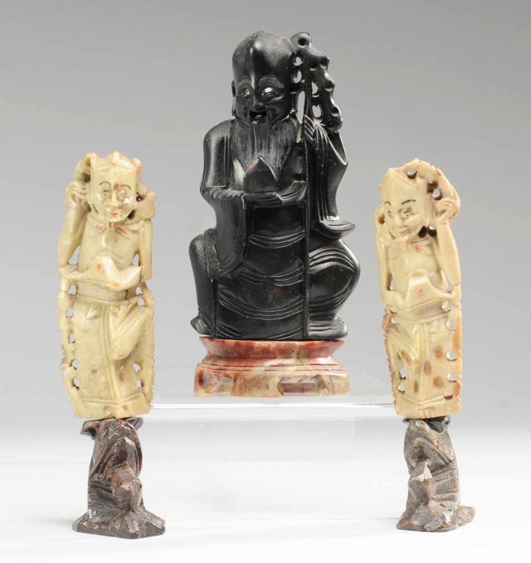 Drei Speckstein-FigurenVersch. farbiger Speckstein, geschnitzt. Auf als Drachenköpfen gestalteten