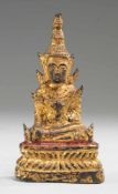 Kleine Figur des Buddha ShakyamuniBronze, part. rot gefasst u. vergoldet. Auf Lotospodest