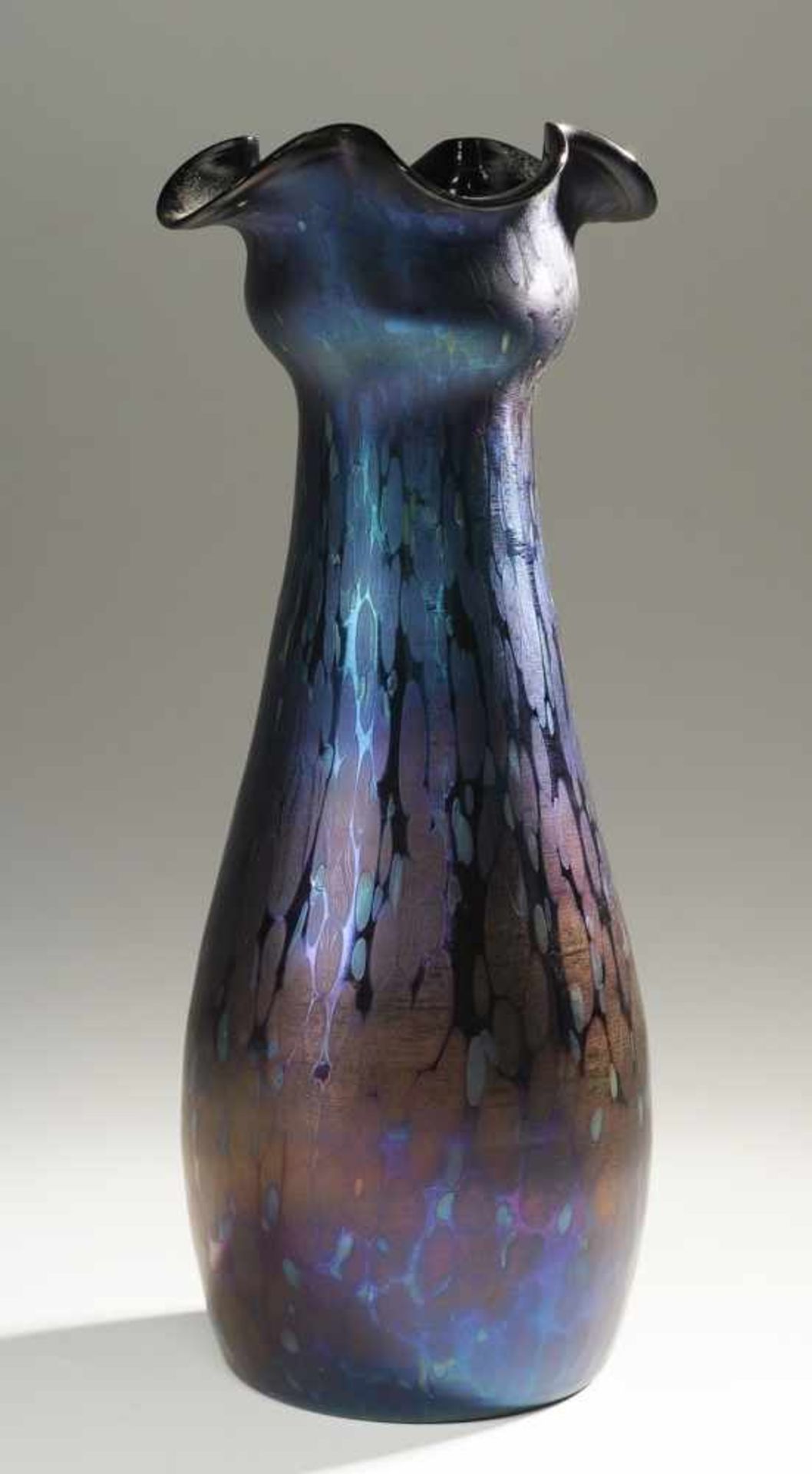 Jugendstil-VaseDunkelviolettes Glas mit silbergelben u. opalweißen Kröselaufschmelzungen.