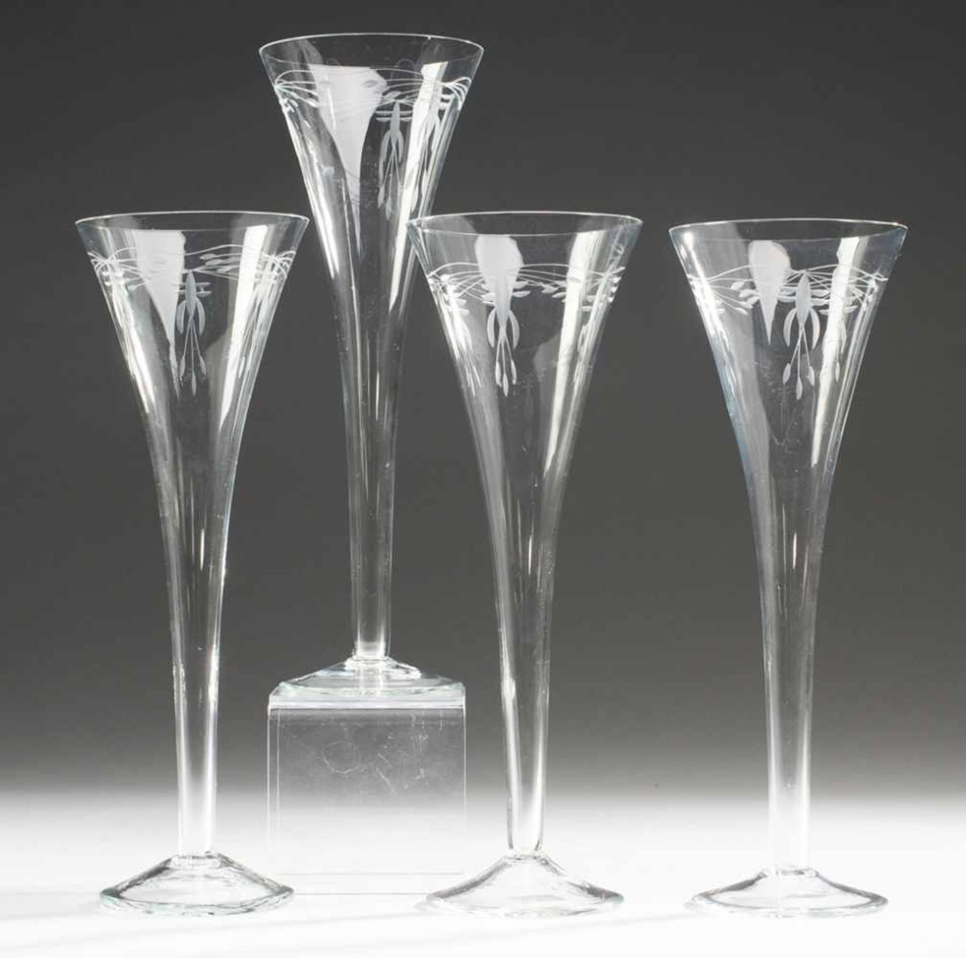 Vier Jugendstil-SektgläserFarbloses Glas. Formgeblasen. Auf l. ansteigendem Fuß gestreckt
