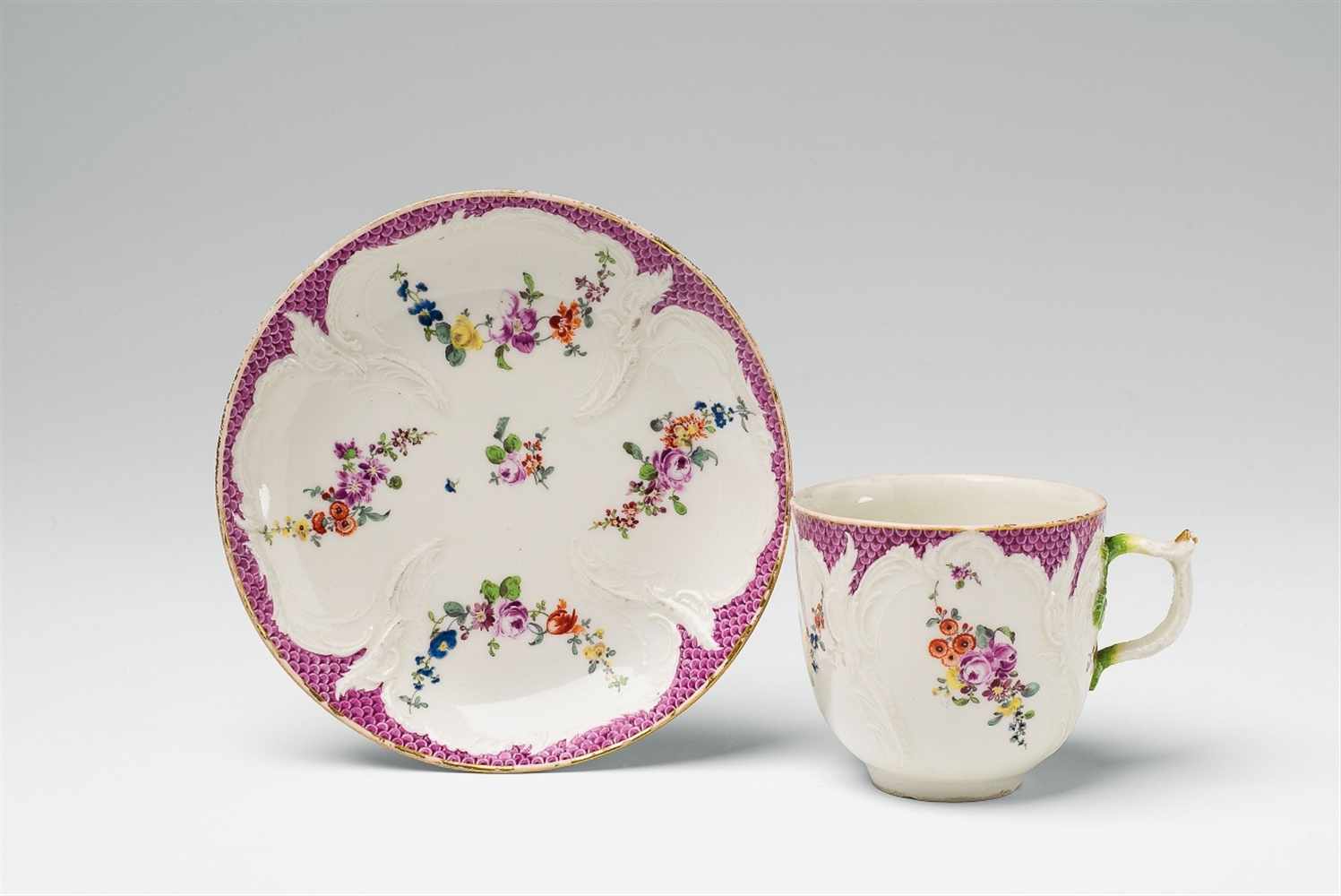 A Berlin KPM porcelain cup from a coffee service with puce mosaic borders Model no. 16, with