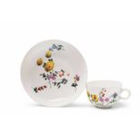 A Wegely porcelain cup and saucer with scattered flowers Blue W mark, the cup impressed 1/W10, the