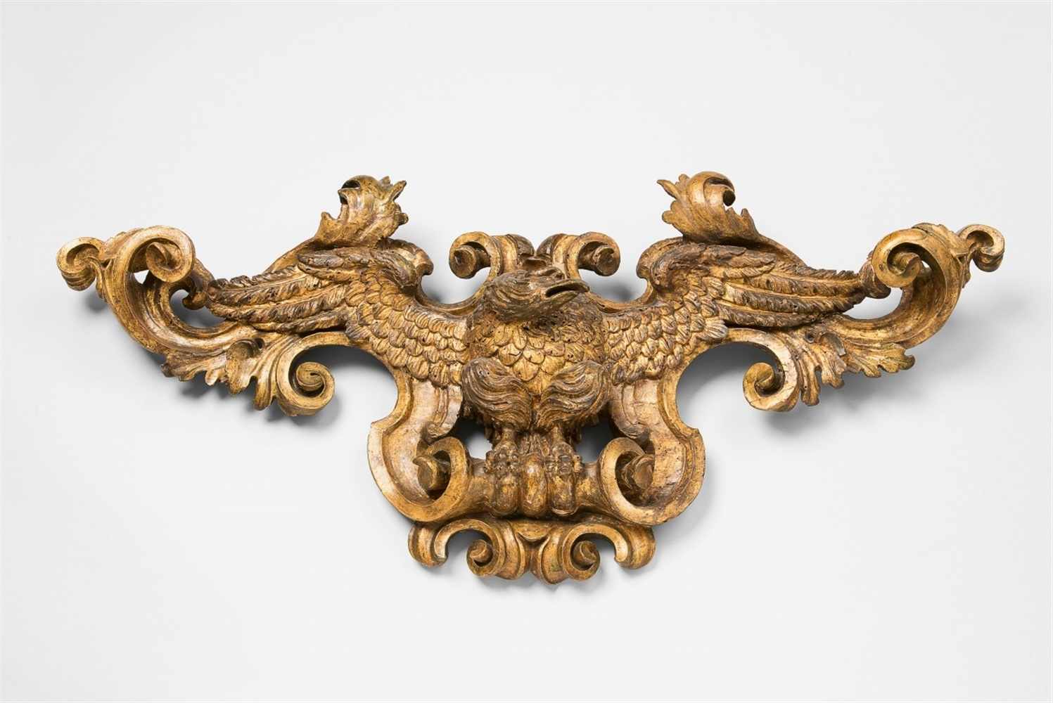 A carved giltwood cartouche with an eagle in flight A dynamic model of a perching eagle with