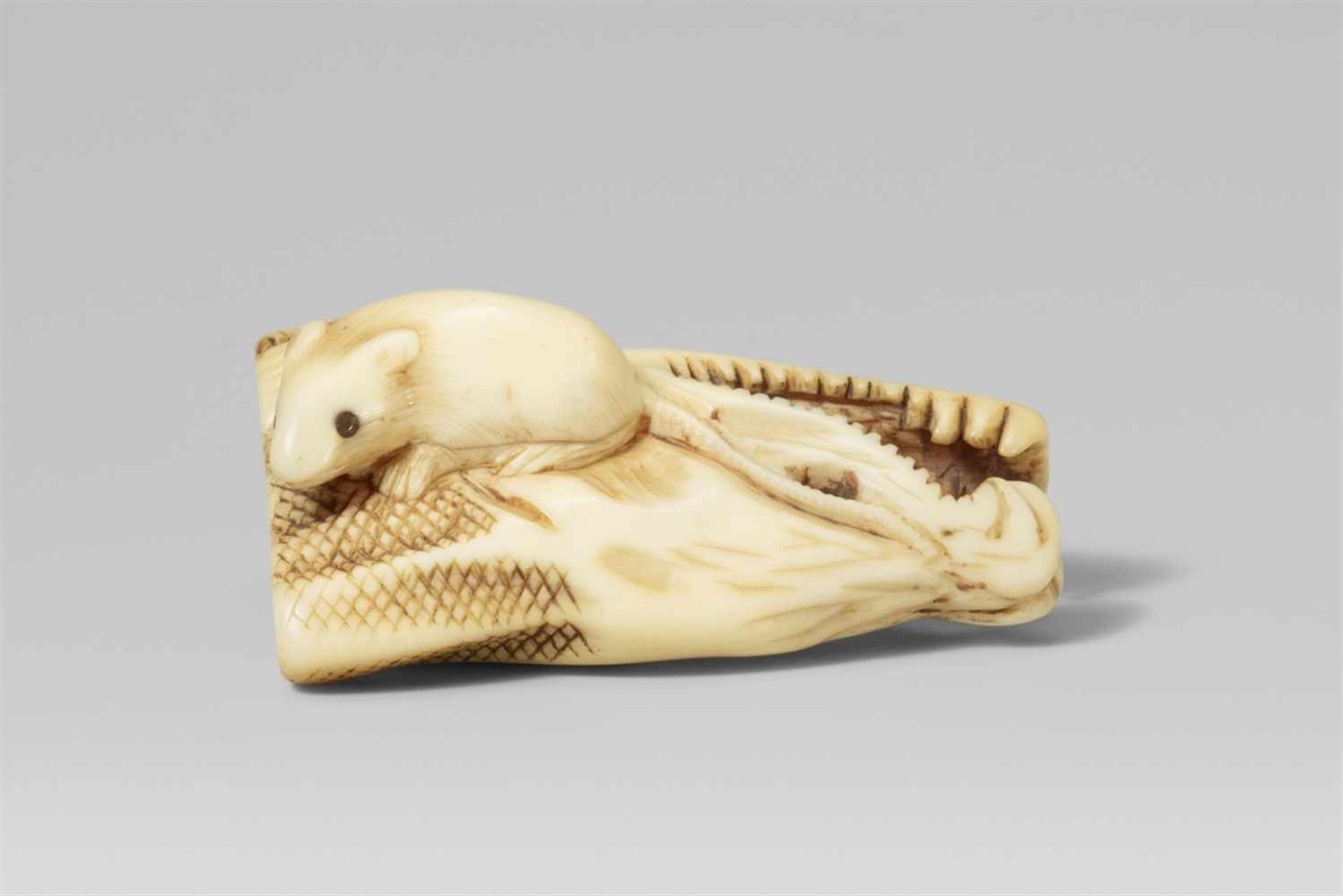 An ivory netsuke of a dried salmon head and a rat. First half 19th century A rat, its head turned to