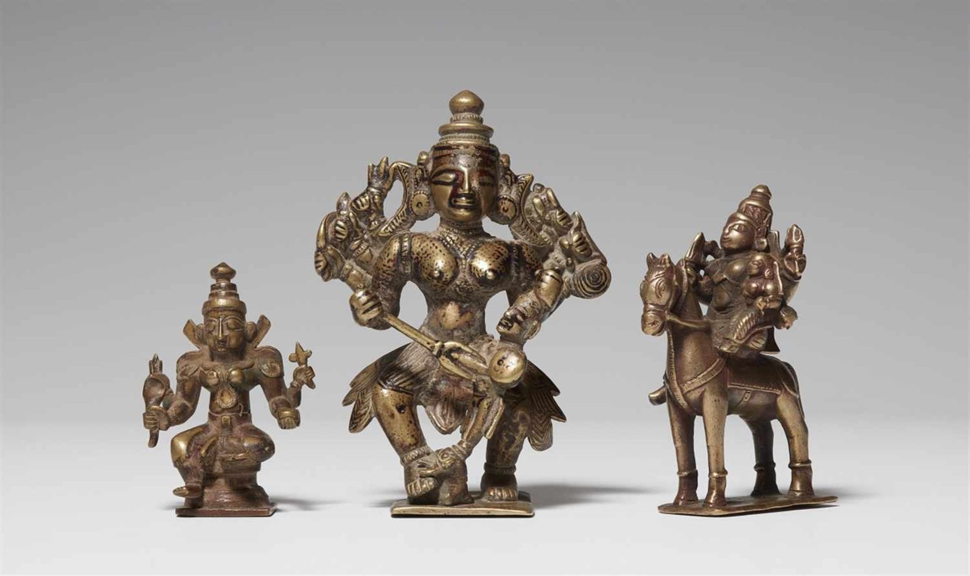 Drei Figuren Gelbguss. Maharashtra. 18./20. Jh. a) Durga. b) Achtarmige Durga, den Büffendämon am