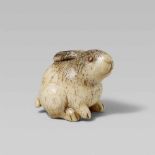 An unusual bone netsuke of a chubby rabbit. 19th centurySeated with head raised. The eye pupils of