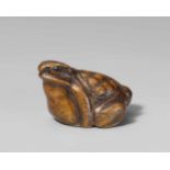 A boxwood netsuke of a toad. Mid-19th centurySquatting in typical pose with head turned to the left.