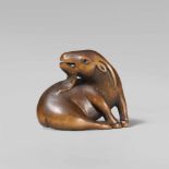 A good wood netsuke of a goat. Mid-19th centurySeated with forelegs placed close together, the