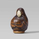 A boxwood netsuke of an Onna-Daruma doll. Late 19th centuryThe body completely covered by the
