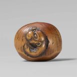 A large boxwood netsuke of a monkey in a chestnut. First half 19th centuryEmerging from a